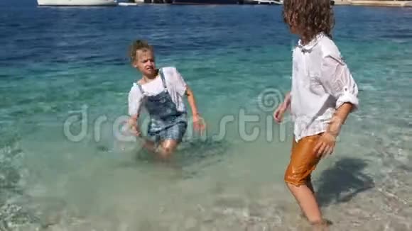 快乐的孩子们在海水中欢乐玩耍孩子们又湿又快乐假期和孩子们在一起学校假期视频的预览图