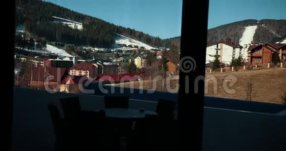 男人走近大的全景窗口欣赏窗外群山的美丽方案缓慢视频的预览图