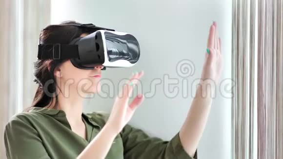 令人惊讶的是集中在VR头盔中的年轻女性在家里打手势视频的预览图