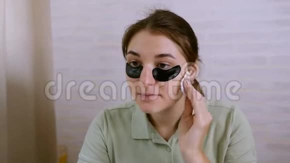 美丽的年轻女人在眼睛周围做皮肤护理皮肤护理概念女孩用棉签清洁皮肤视频的预览图
