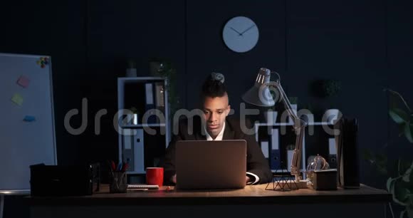 沉睡的商人喝咖啡晚上在笔记本电脑上工作视频的预览图