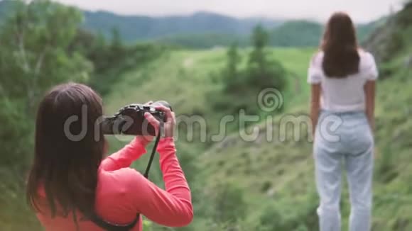 一位摄影师在山上拍摄一位模特游客视频的预览图