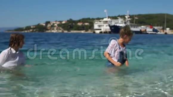 在巴尔干度假的学生纯净的海水地中海小镇背景上两个快乐的孩子视频的预览图
