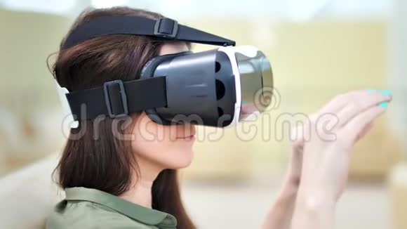 在虚拟现实游戏中戴着虚拟现实眼镜的年轻女士的特写镜头视频的预览图