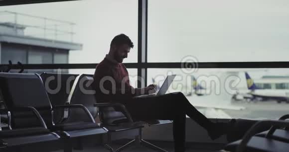在机场的一个等候区商人用他的笔记本在银行卡上转账直到他视频的预览图