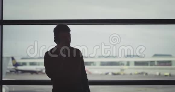 他微笑着大个子在电话里说话直到他在机场等候区等待他的航班然后他走到视频的预览图