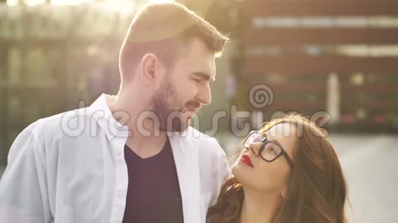 微笑的情侣在户外恋爱年轻的幸福夫妇拥抱在城市街道上视频的预览图