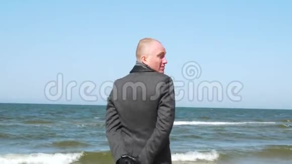 时髦的男人带着我的手势和眨眼优雅自信的年轻商人在海滩上挥手视频的预览图