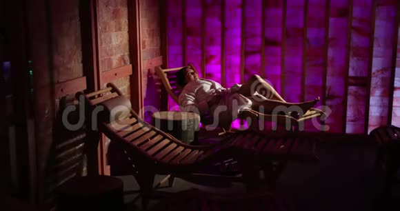 一个女人住在一个昂贵的旅馆里一个在盐湾的木制休息室里粉红墙治疗桑拿治疗医学视频的预览图