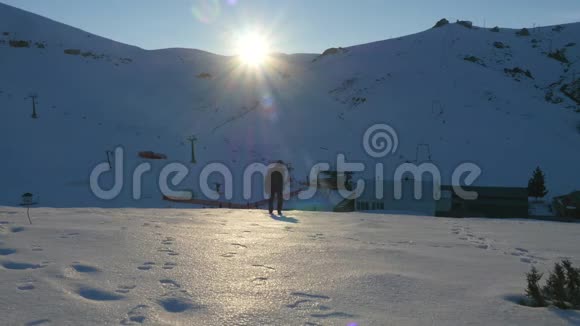 穿着深色衣服的年轻人慢慢地走上雪山视频的预览图