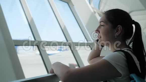 年轻女子正在飞行区机场候机楼用手机交谈视频的预览图
