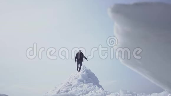 在冰川上行走的孤独的男性游客令人惊叹的雪景北极或南极冰块在上面视频的预览图
