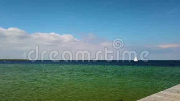 4K视频白色风车站在清澈的绿松石北海一艘豪华游艇正慢慢地从他们身边经过它在里面视频的预览图