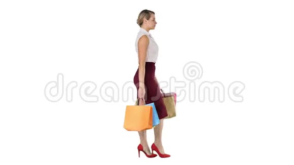 快乐全长的女人手里拿着纸购物袋走在白色的背景上视频的预览图