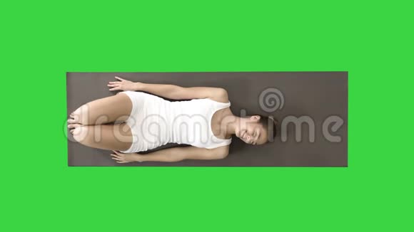 瑜伽女人笑着躺在绿色的屏幕上铬钥匙视频的预览图
