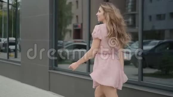 开朗的年轻女子无忧无虑地走过夏天的城市视频的预览图