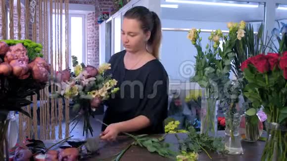 花商在花店里创作桉树桉树牡丹和鸢尾花束视频的预览图