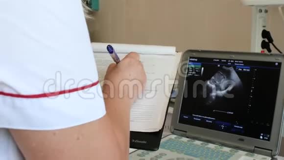 一位超声波医生把一名早产儿的超声波的证词写在他的医疗单上4k4k视频视频的预览图