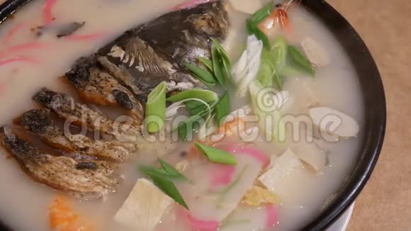 中餐厅桌上砂锅蒸鱼头的运动视频的预览图