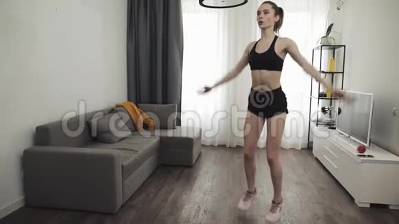 年轻的健身妇女在家庭内部训练晨练慢动作侧跨跳练习健康和健康视频的预览图