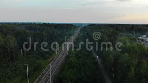 白色SUV在公路上行驶平行铁路空中观景视频的预览图
