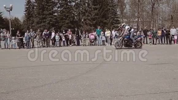 骑摩托车的人把自行车放在后腿上骑自行车站在座位上视频的预览图