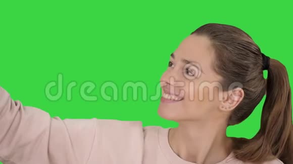 微笑欢快的金发女人在绿色屏幕上自拍Chroma键视频的预览图