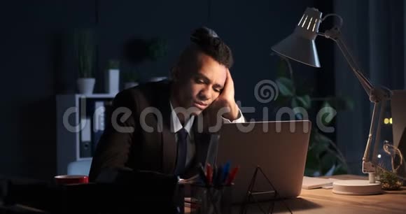 商人深夜在笔记本电脑上工作时睡着了视频的预览图
