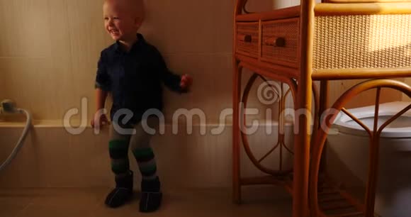 小金发男孩在洗衣机旁边的浴室里跳舞视频的预览图