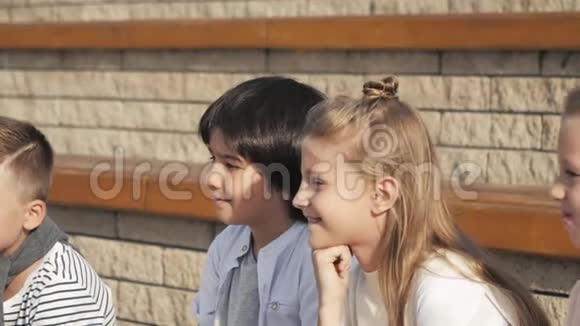 可爱的男孩和女孩坐在公园里视频的预览图