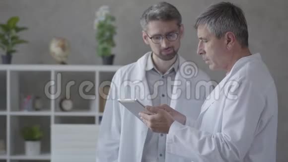 两名男医生检查药片上的信息讨论医学技术保健和人民的概念视频的预览图