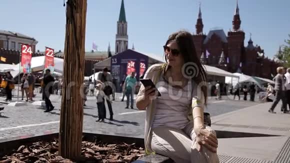 一名使用智能手机的妇女在克里姆林宫前的莫斯科红场讲话视频的预览图