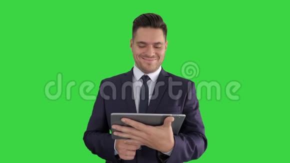 成熟英俊的情感商人在绿色屏幕上的数字平板电脑上的流行网站上观看有趣的视频视频的预览图