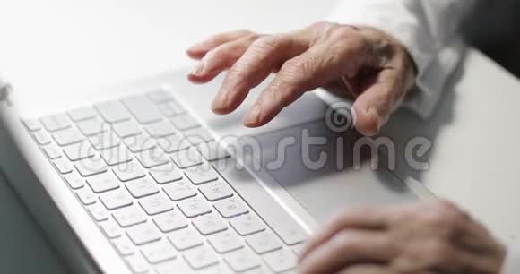 一位在键盘上打着皱纹的老年妇女的手的特写视频的预览图