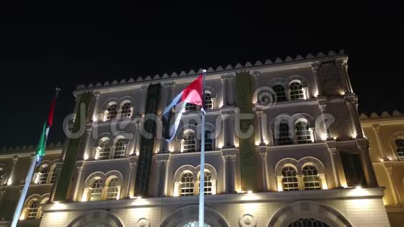 阿拉伯联合酋长国旗在沙迦市AlQasba地标旁夜间飘扬视频的预览图