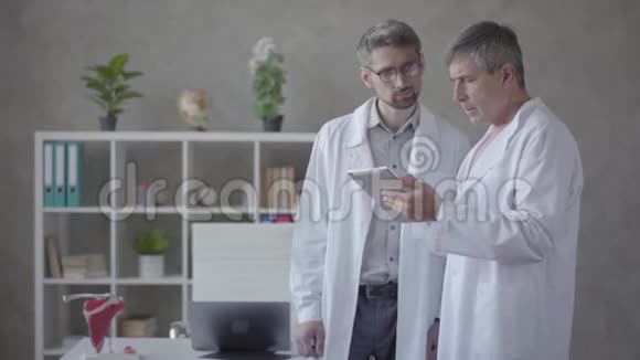 两名男医生检查药片上的信息讨论医学技术保健和人民的概念视频的预览图
