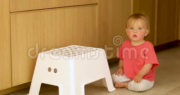 可爱的孩子坐在地板上坐着白色的椅子视频的预览图