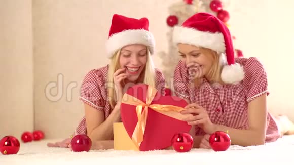新年女友圣诞树旁壁炉旁的年轻女朋友礼物新年概念圣诞节视频的预览图