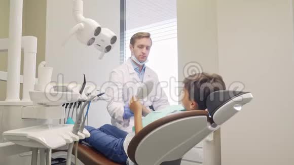 快乐的小男孩和他的牙医对着镜头微笑视频的预览图
