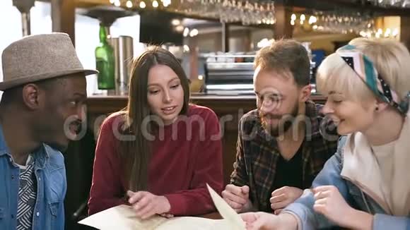 一群时髦的朋友在酒吧酒吧里阅读菜单和选择菜肴视频的预览图