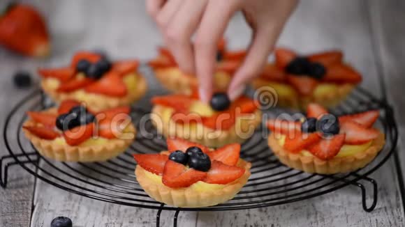 美味可口的夏季小馅饼配上新鲜的奶油蛋奶油馅配上草莓和蓝莓视频的预览图
