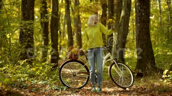 秋天的女人在秋天的公园里穿着绿色的套头衫秋季年轻美丽女士户外时尚照片视频的预览图