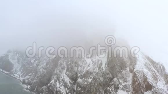 在无人驾驶飞机下雪的时候拍摄岩石和海岸视频的预览图