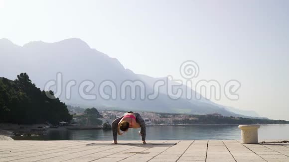 早上阳光海边运动健身女子瑜伽训练视频的预览图