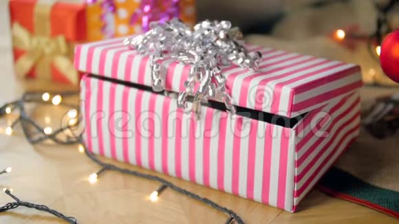 圣诞老人送的圣诞礼物盒里坐着一只可爱的灰色小猫的慢动作视频视频的预览图