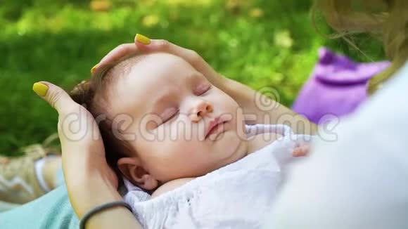 可爱的新生婴儿睡在外面的大腿上有爱心的母亲视频的预览图