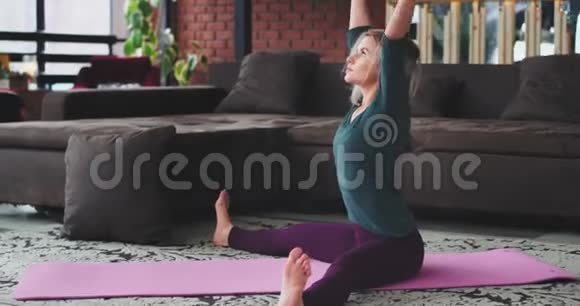 瑜伽伸展身体年轻女士金发碧眼早上在垫子上练习有一个大顶楼视频的预览图