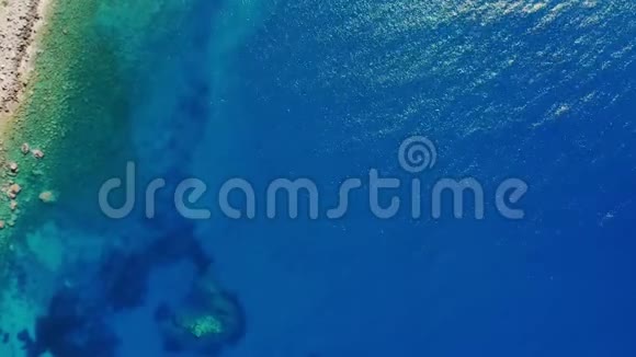 空中俯视阳光下爱琴海的绿松石蓝色水域海岸线视频的预览图