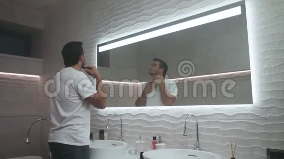 帅哥在豪华浴室里刮胡子专心致志的男人在浴室刮胡子视频的预览图
