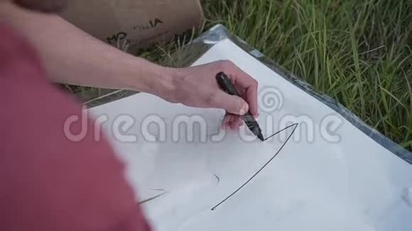 这家伙画了一个标记计划来建造一个自制的纸板火箭用记号笔将脸部和双手特写视频的预览图